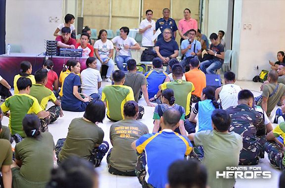 The production team of Songs for Heroes 2 meets with the performers from the AFP and PNP during one of the concert’s rehearsals.